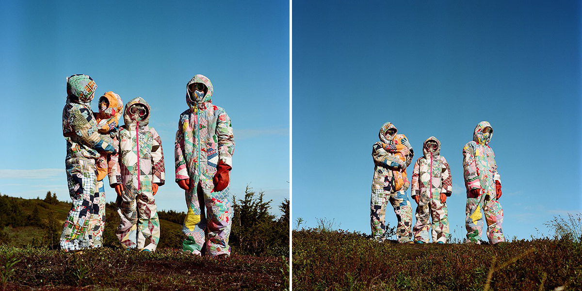 A family of four stands in grass with a blue sky background.