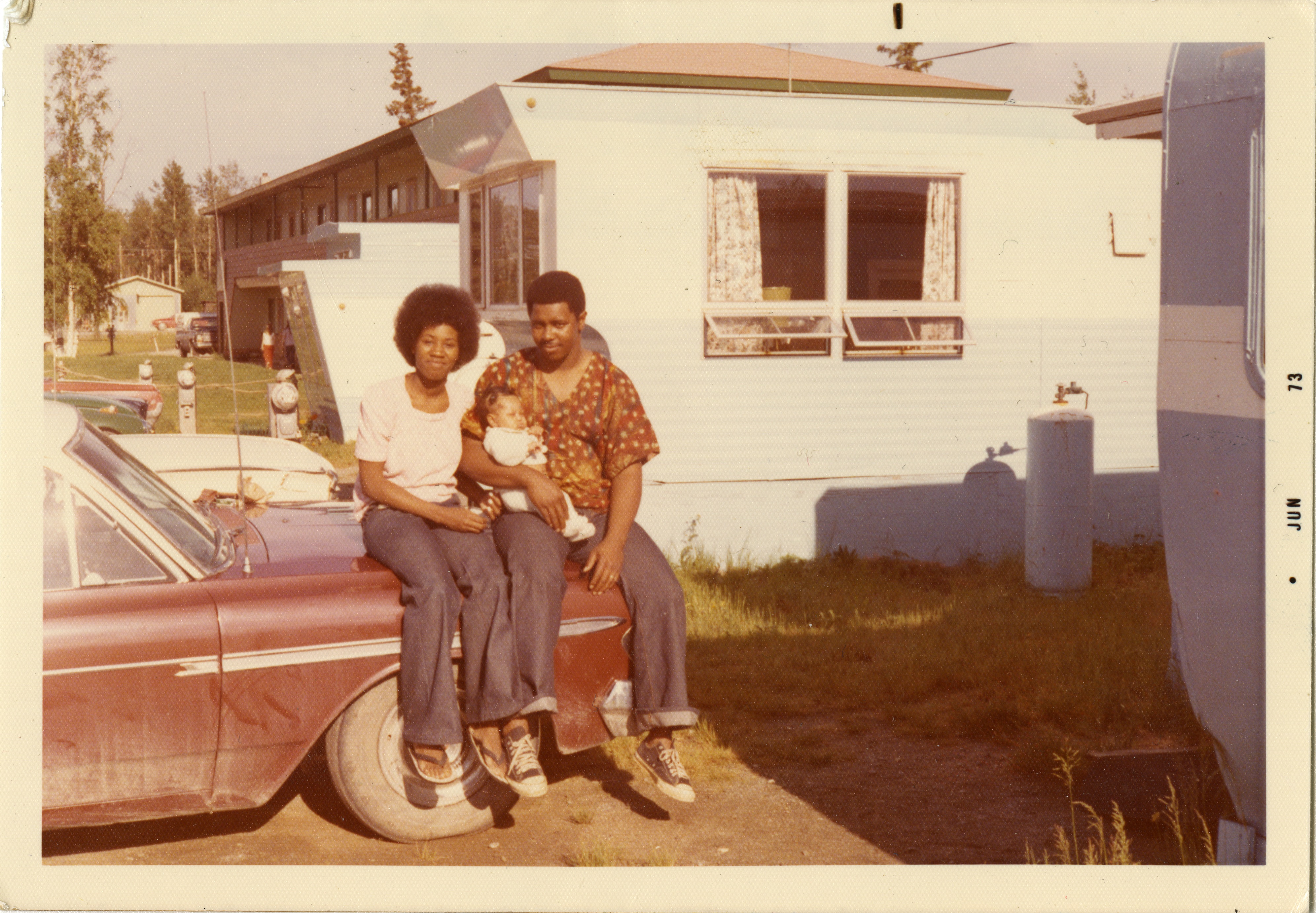 Ed and Frances Wesley with their baby daughter, Chairita, in front of the Armstrong Apartments in Delta Junction, 1973